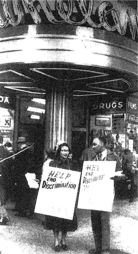 Ina Sugihara and Charles Crawford at a protest in 1953. They are holding signs that read "Help End Discrimination."