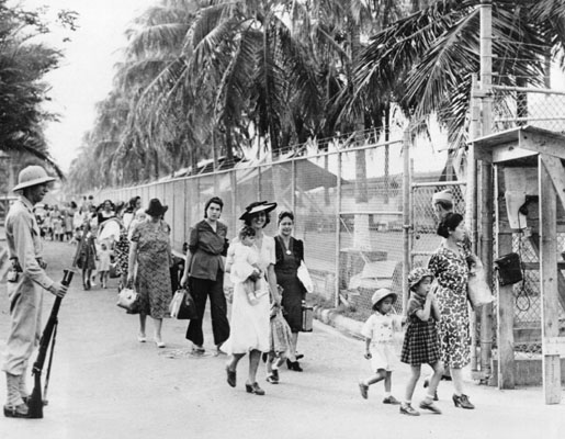 Women and children being escorted out of an internment camp in the Panama Canal Zone before they are transferred to one in the United States in April 1942.