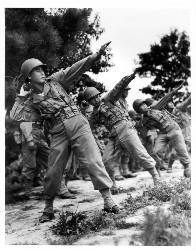 Japanese American soldiers practice throwing grenades in basic training at Camp Shelby, Mississippi.