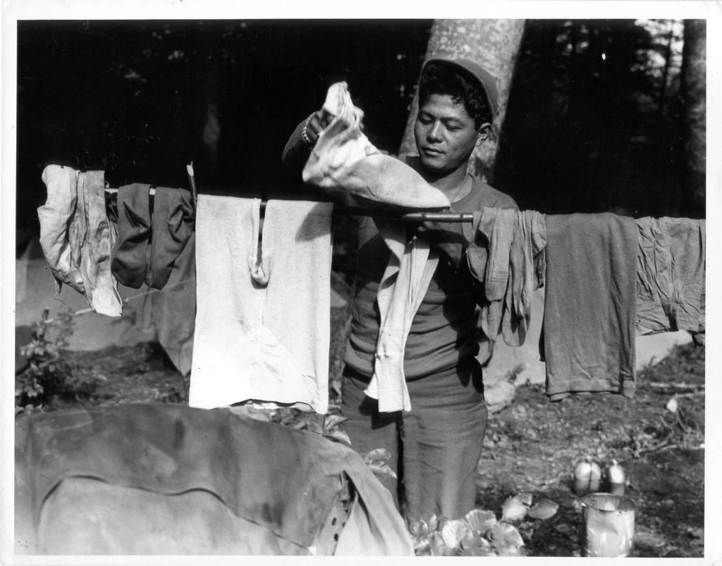 Japanese American soldier hanging laundry out to dry.