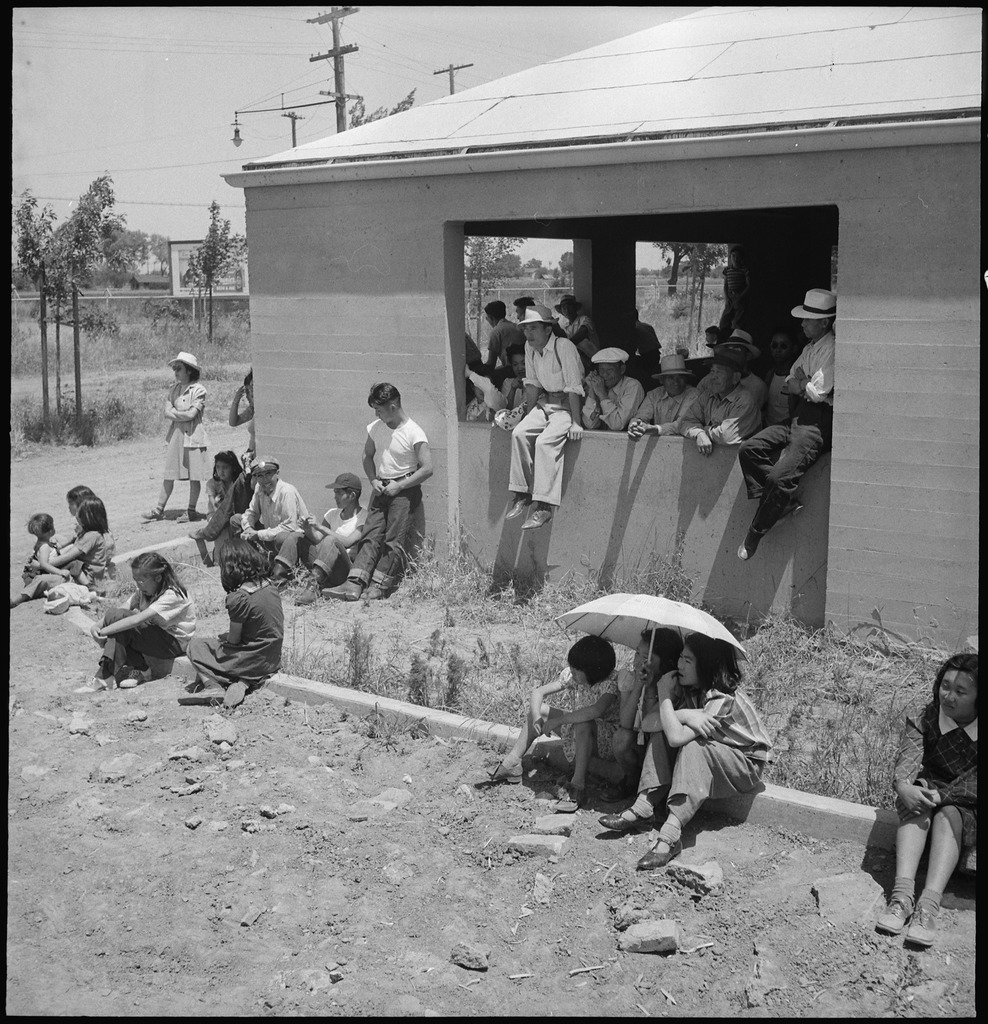 Japanese Americans watching the arrival of buses bringing more families at the Stockton Assembly Center.