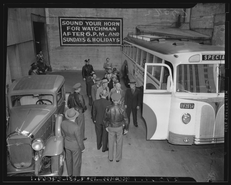 FBI agents ushering Japanese Americans arrested in raids following Pearl Harbor onto a bus.