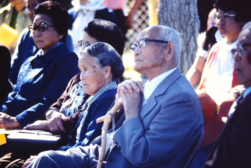 Two elderly Japanese Americans listen to a remembrance program at the 1974 Tule Lake pilgrimage