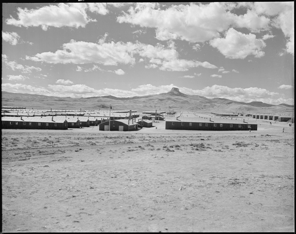 Photo of barracks at Heart Mountain concentration camp. Heart Mountain is visible in the background.