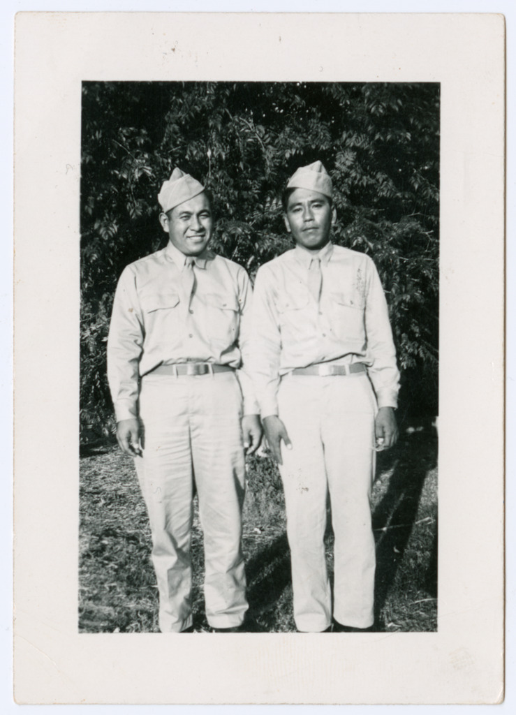 Two Japanese American soldiers wearing khaki uniforms and standing side by side for a photo.