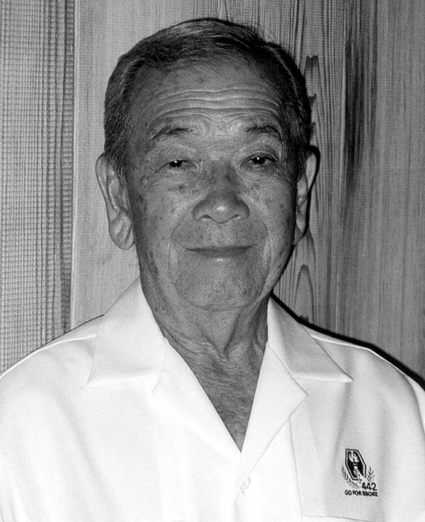 Portrait of Yukio Okutsu wearing  a white colored shirt with 442nd/Go For Broke insignia on the chest.