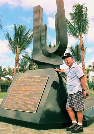 Bumpei Akaji standing next to a monument to Japanese American veterans in Hawai'i.