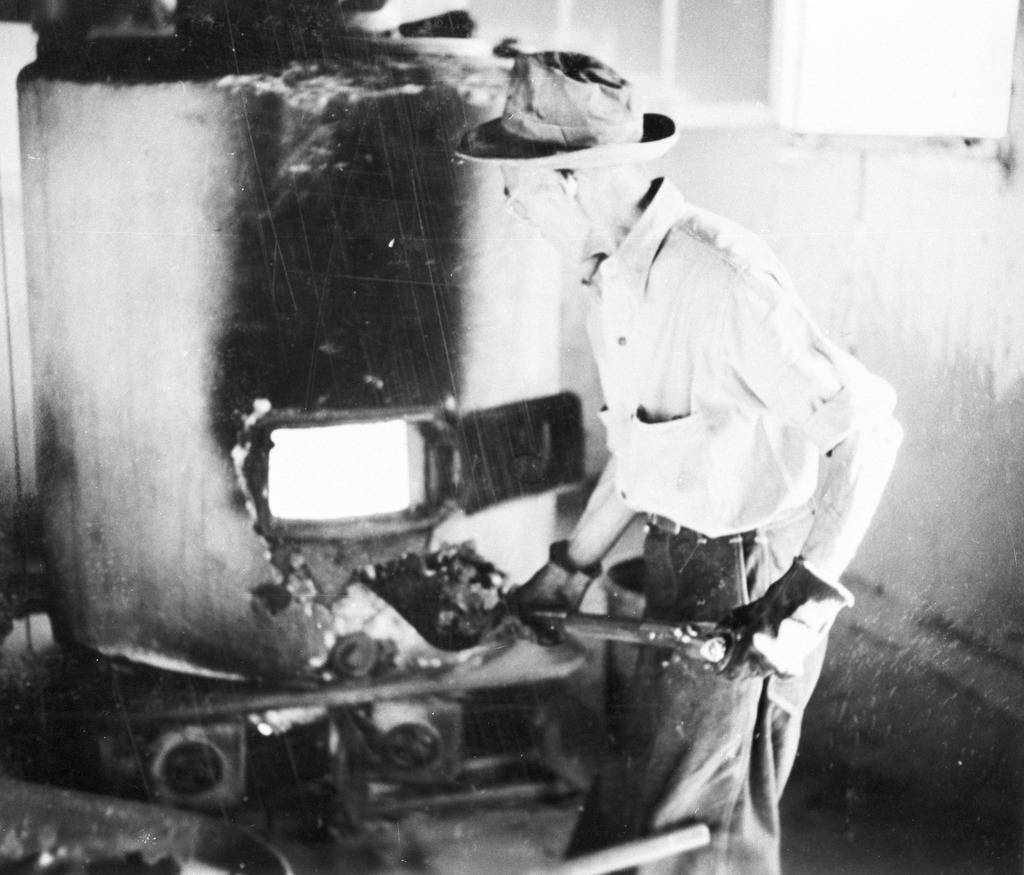 A man shoveling coal into a furnace at Minidoka.