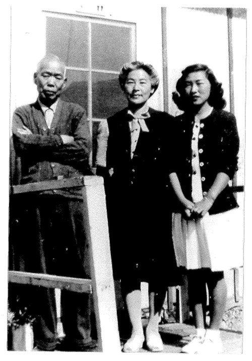 Donna Nagata's mother and grandparents standing on the steps in front of their barrack in Topaz concentration camp during WWII.
