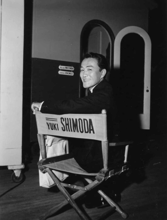 Yuki Shimoda sitting in an actor's chair with his name on the back.