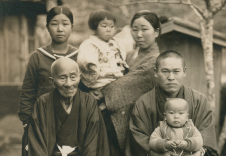 Japanese family wearing kimono pose for a photo outside.