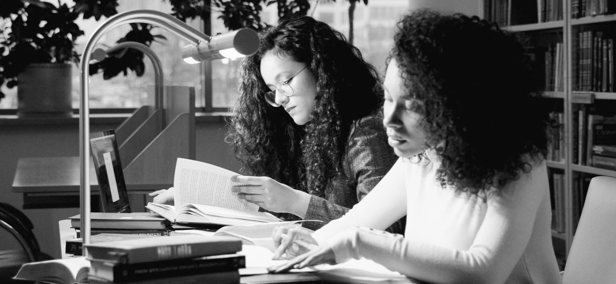 Two students research at a library