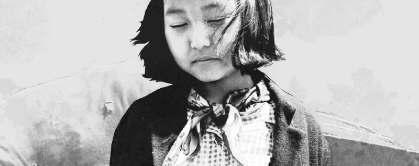 Young Japanese American girl looks down with her eyes closed.