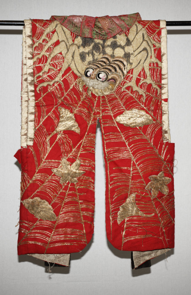 A red cotton vest from a shibai performance, featuring a gold embroidery spider with glass eyes.