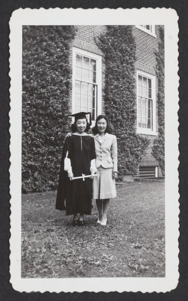 Yoshiko Uchida and another young woman, likely her sister Keiko, at her graduation from Smith College. Yoshiko is wearing a graduation cap and robe and holding her diploma.
