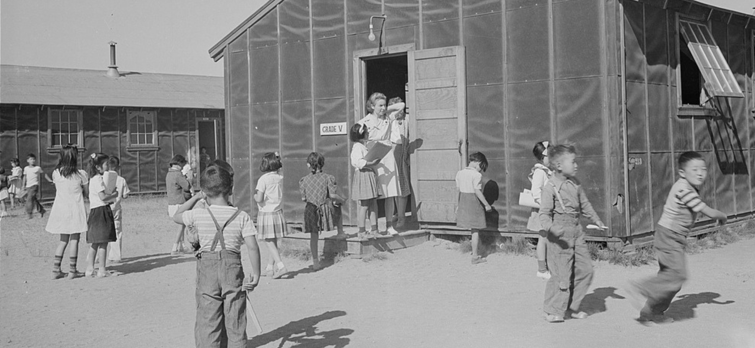 children play outside a barrack