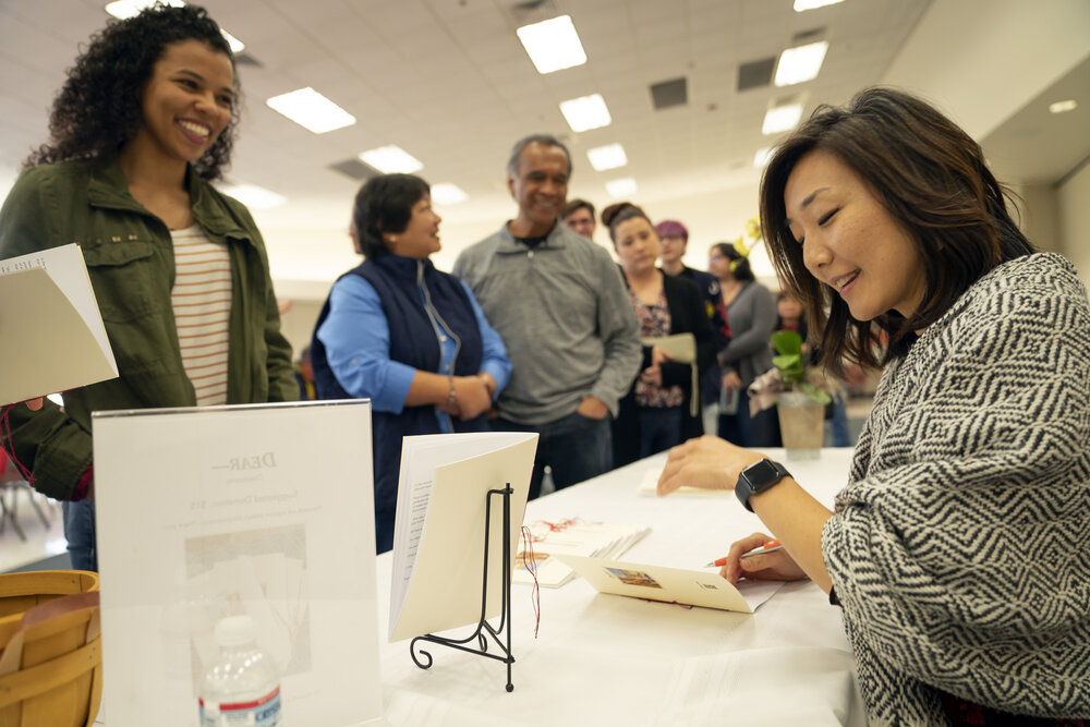 Brynn Saito signs chapbooks at the February 2020 launch event.