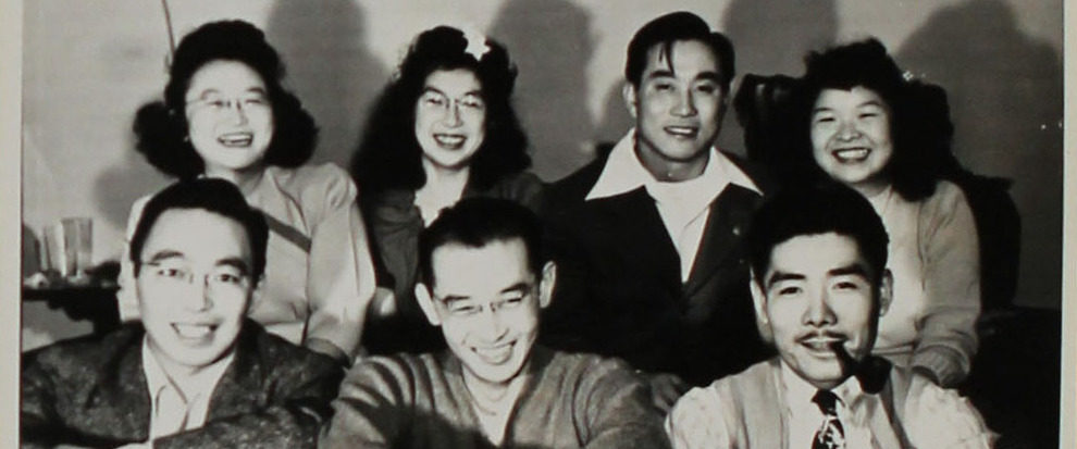 A group of Japanese American friends sitting together and smiling.