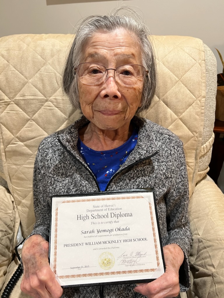 Sarah Yomogi Sato holding an honorary diploma from President William McKinley High School in March 2021.