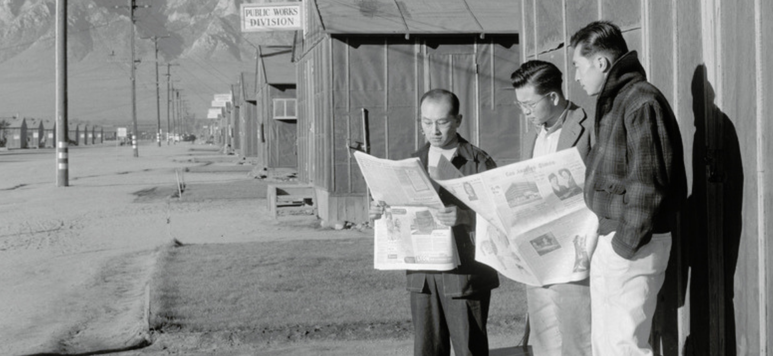 Japanese Americans in front of camp newspaper office