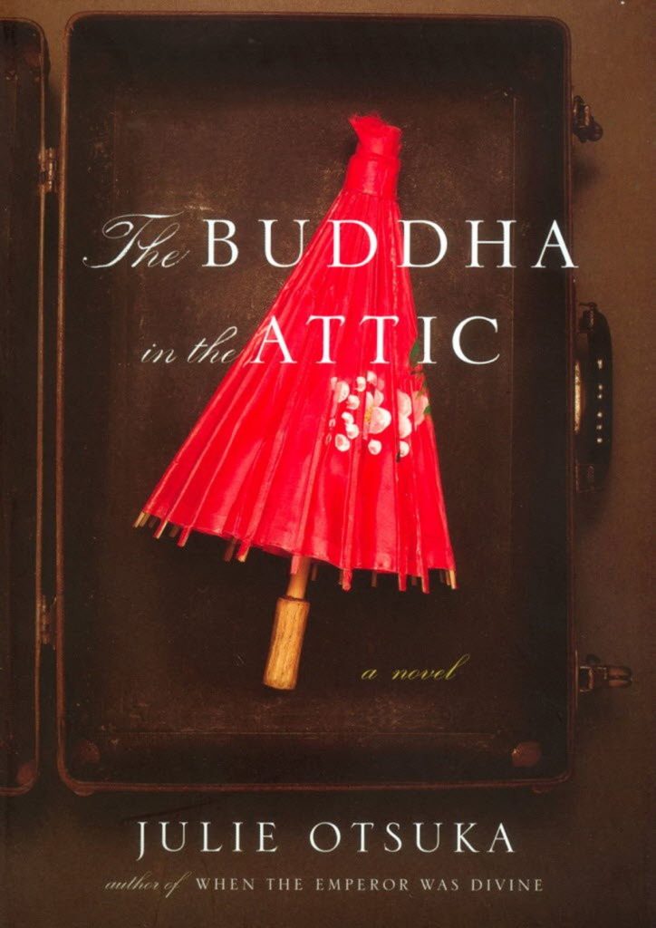 Book cover of The Buddha in the Attic by Julie Otsuka. It shows a red parasol inside an open suitcase.