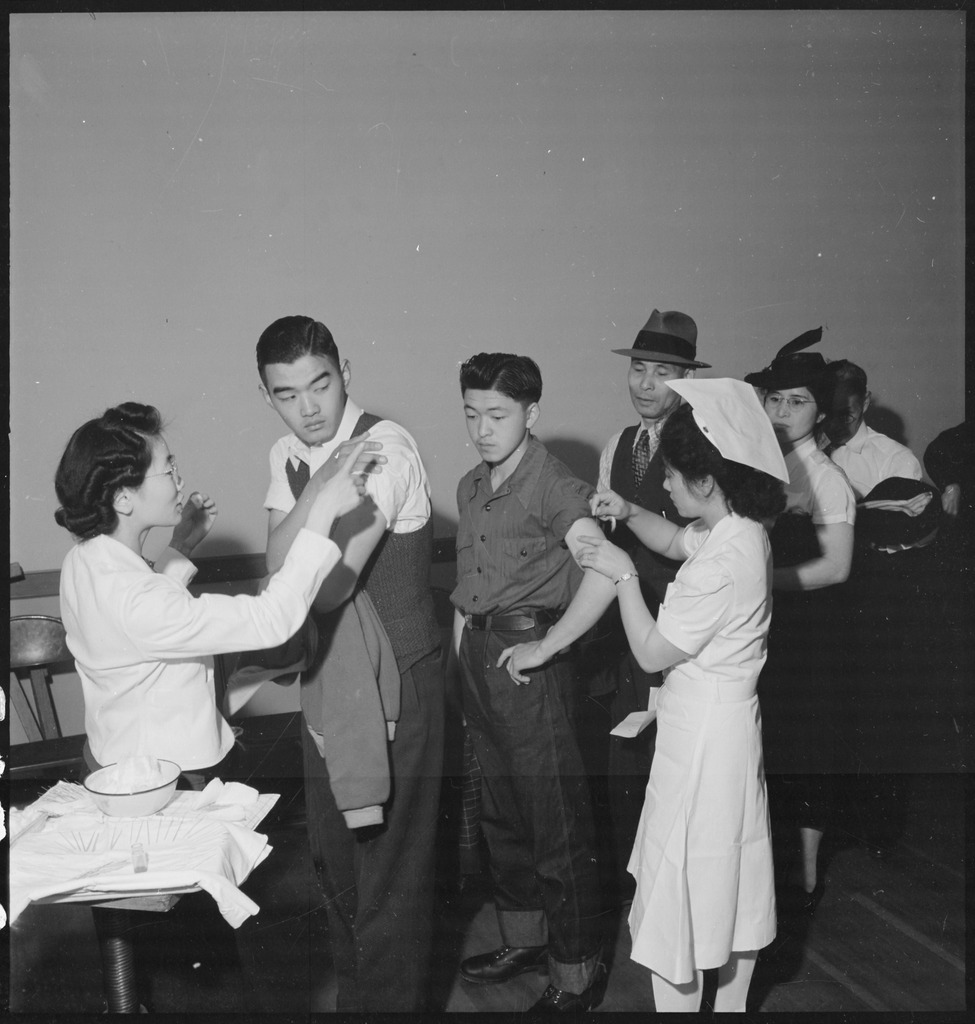 Japanese Americans reciving typhoid vaccinations while registering for forced removal in 1942.
