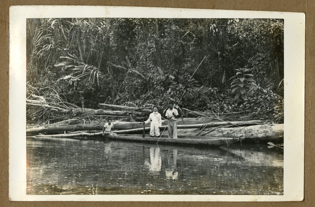 Three Japanese Peruvian men in a canoe on a river.