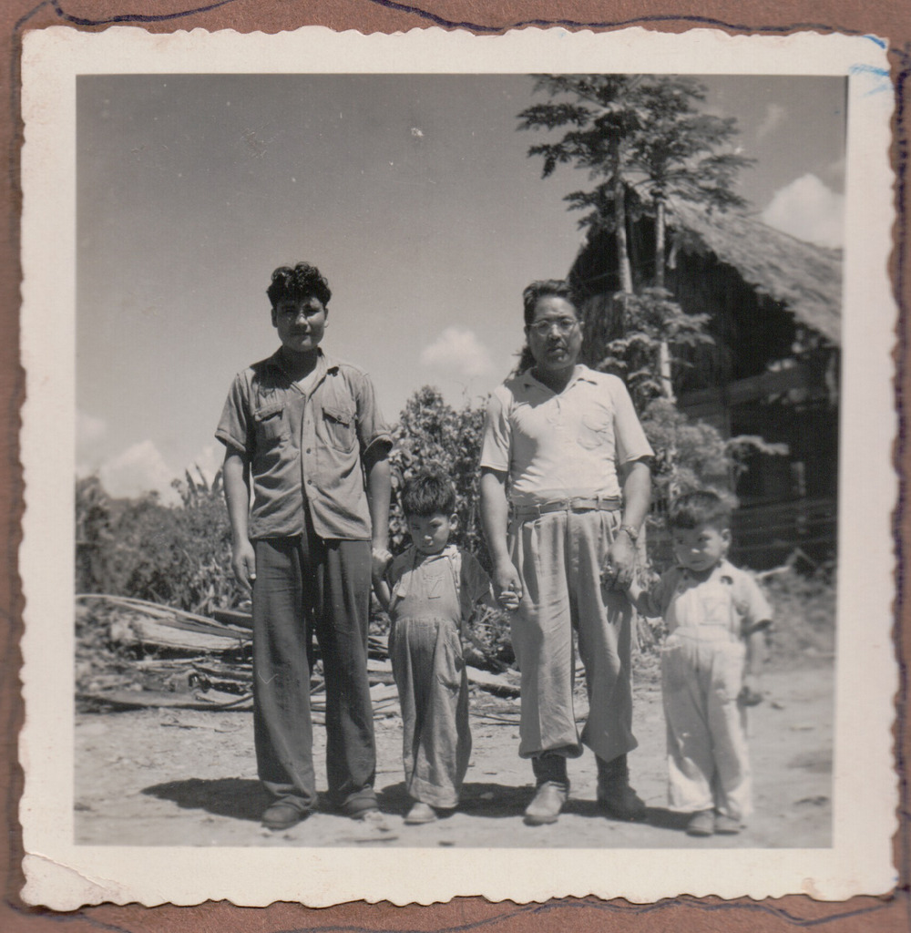 Two Japanese Peruvian men and two young boys on a plantation.