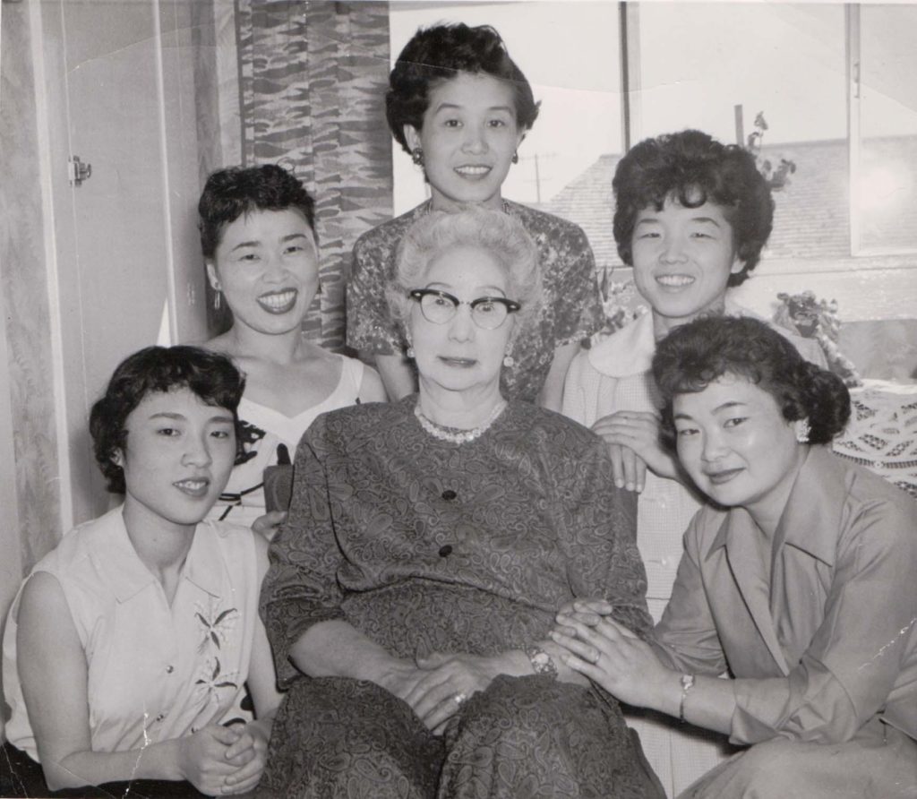 Aya Hori Masuoka seated surrounded by several young Japanese war brides in 1960.