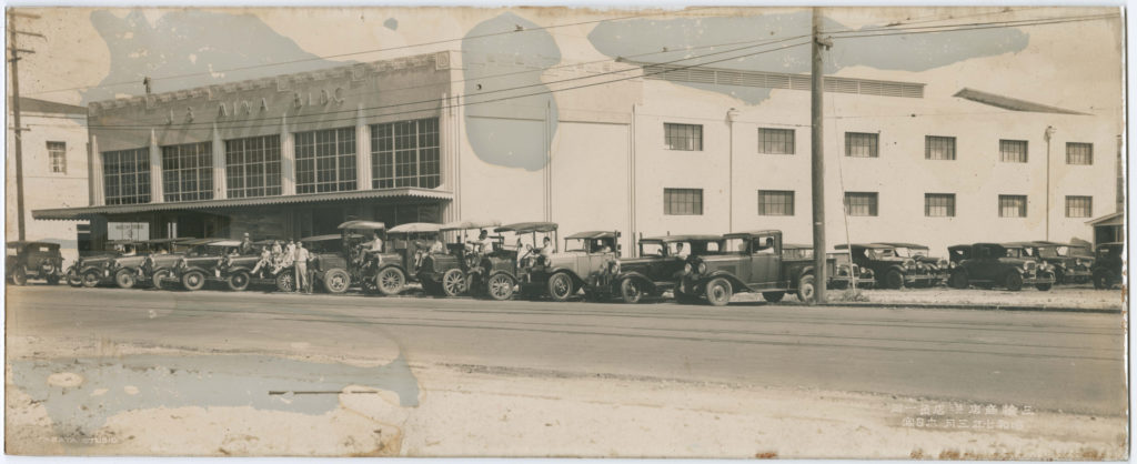 The JS Miwa Building in 1932. The Miwa family is posing next to a row of cars parked on the street out front.