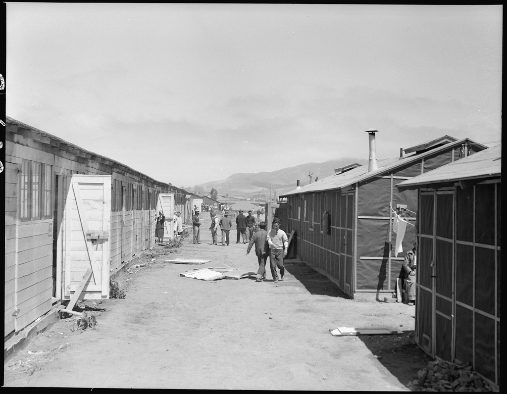 People walking between barracks at Tanforan Assembly Center.