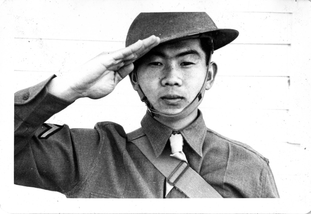 Japanese American soldier in US Army uniform performing a military hand suit
