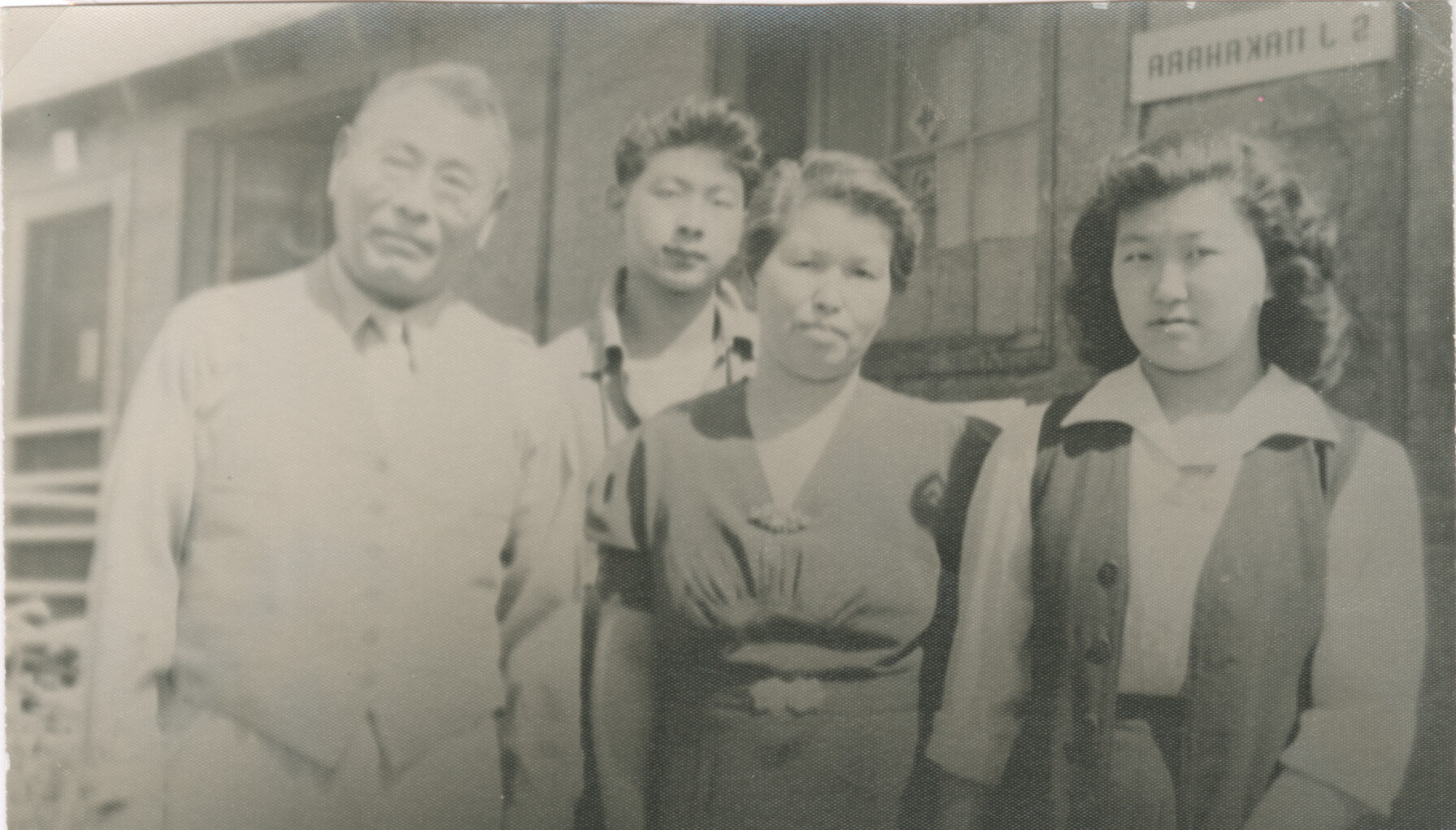 A Japanese American family standing in front of barracks at Minidoka.