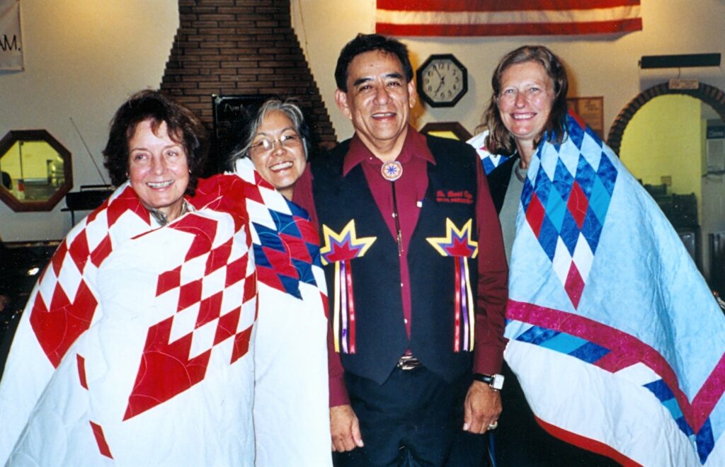 Native star quilts presented by United Tribes to key planners of the Snow Country Prison Traveling Exhibit that opened at UTTC in 2003. From left, Laurel Reuter, Dr. Satsuki Ina, David M. Gipp, and Karen Ebel.