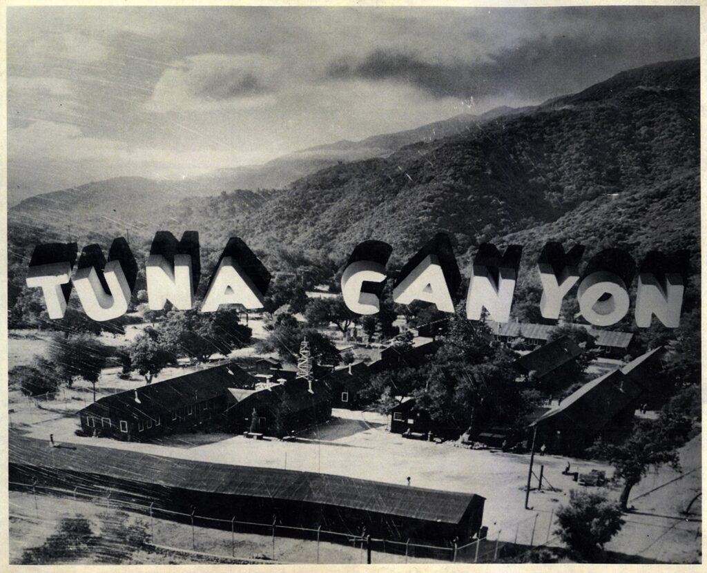 Model of Tuna Canyon Detention Facility with barracks and a sign in the hills behind the camp that reads 