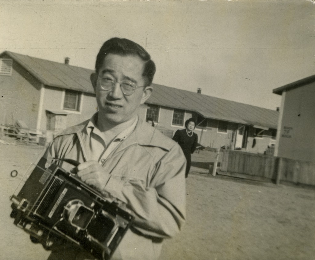 Self portrait of George Ochikubo holding his camera in Amache concentration camp.