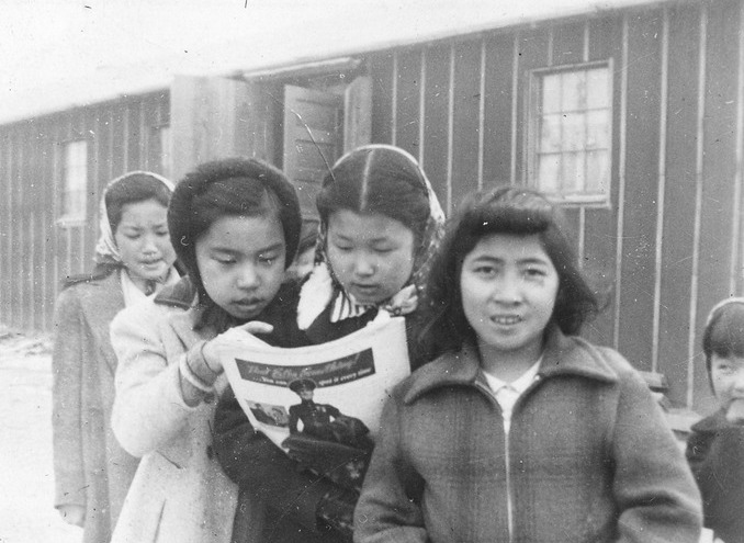 Four Japanese American grade school students in front of a barrack in Heart Mountain concentration camp.