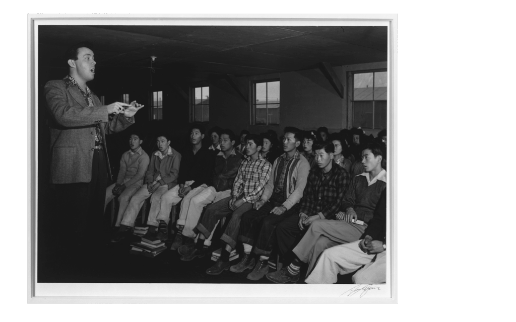 Music teacher Lou Frizzell directing a choir practice in Manzanar in 1943.