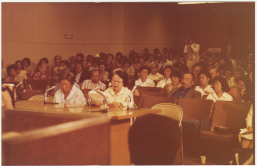 Speakers testify at the Los Angeles hearings of the Commission on Wartime Relocation and Internment of Civilians as attendees listen.