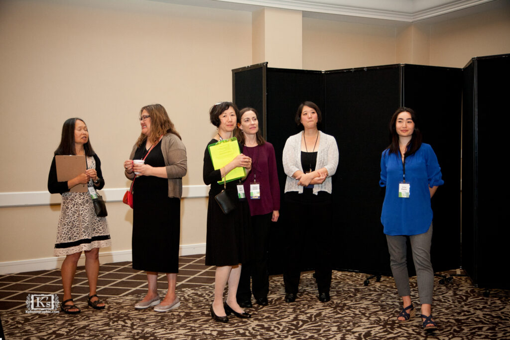 Group photo at 2016 Densho 20th Anniversary Gala. Naoko stands in the center with a bright green clipboard. Credit Kazuko Wohlers.