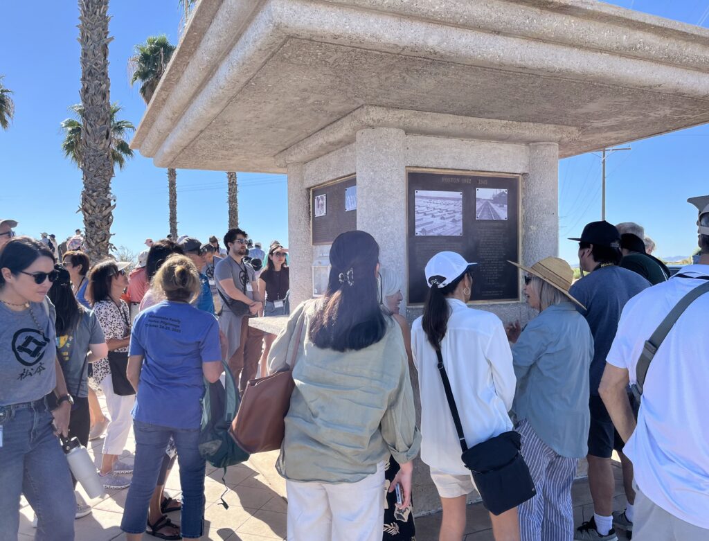 Pilgrims gathered around the Poston memorial.