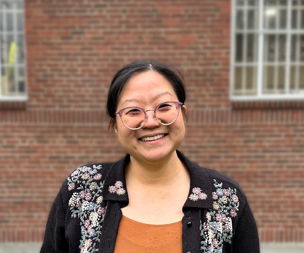 Maya Hayashi smiling in front of a brick building
