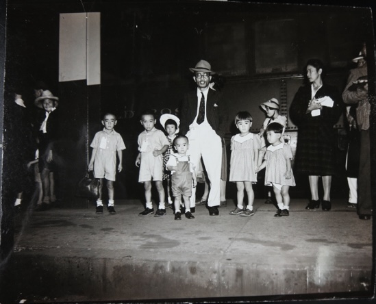 Children with a couple of adults stand in front of the M.S. Gripsholm at the Port of New Jersey/New York on September 2, 1943. U.S. Navy Official Photo, National Archives at College Park, Maryland.