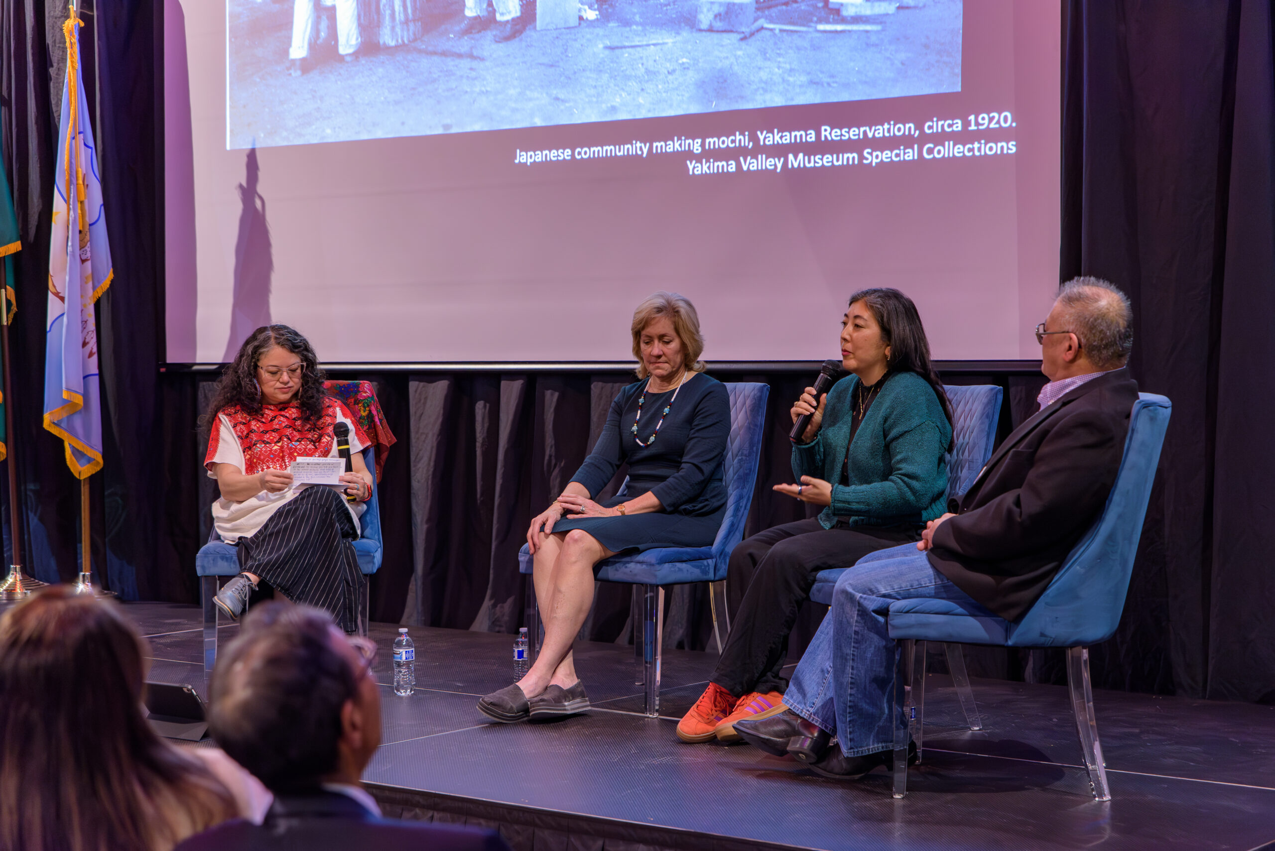 Caitlin Oiye Coon, alongside speakers, on stage speaking at the Yakima Valley Museum’s Day of Remembrance event. February 19, 2026.