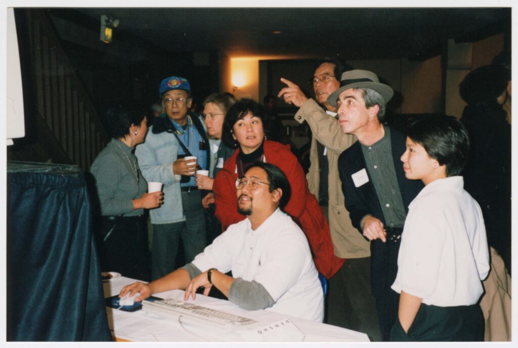 Staff member operating computer for Densho Opening Gala attendees