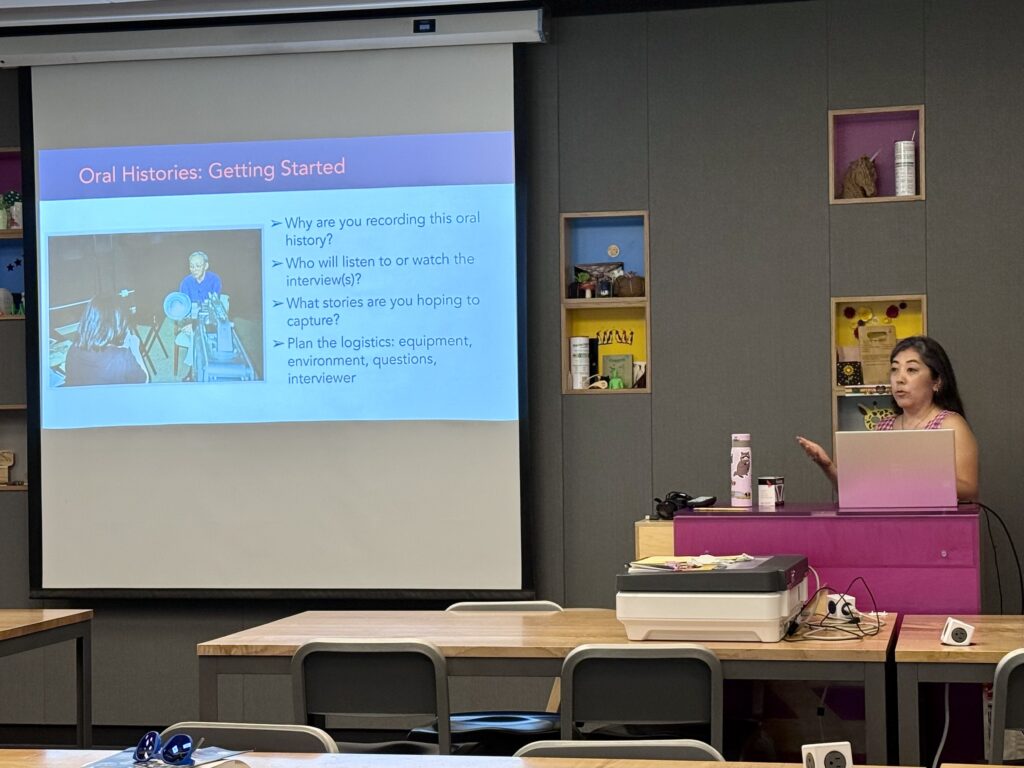 Densho Archives Director Caitlin Oiye Coon stands in front of room and advises on how to conduct oral histories. Slide next to her says: "Oral Histories: Getting Started."