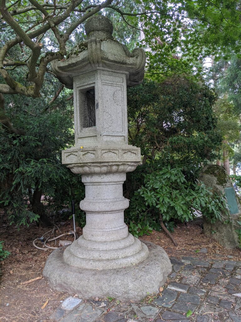 Image of Japanese lantern in a garden with lush greenery and trees surrounding