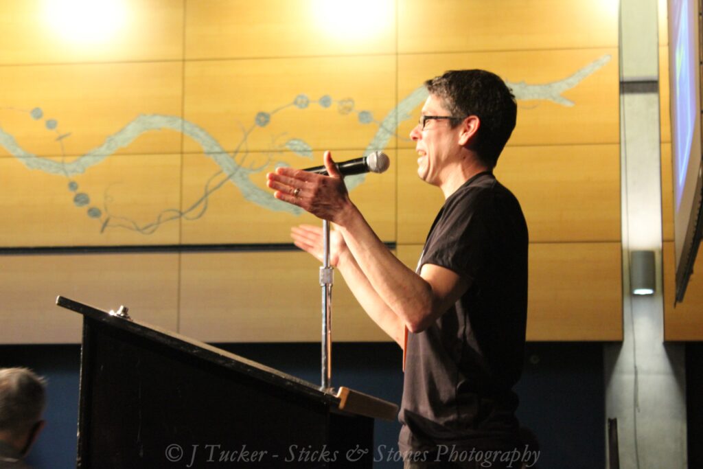 Man speaking behind a podium talking into a microphone