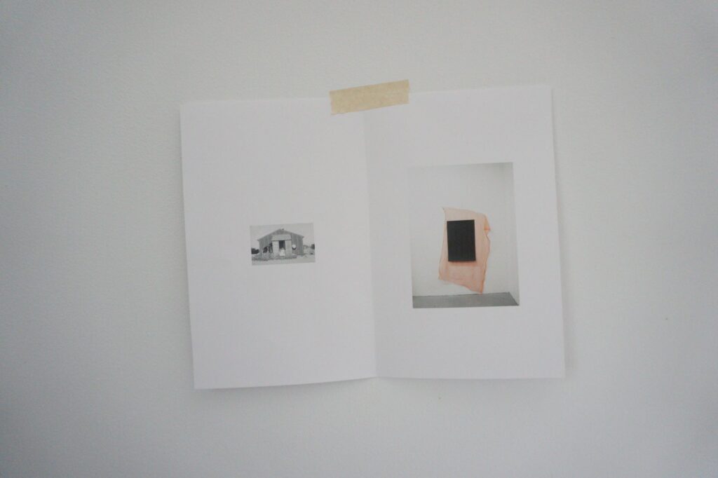 Image of an open book featuring two small images with a piece of tape at the top